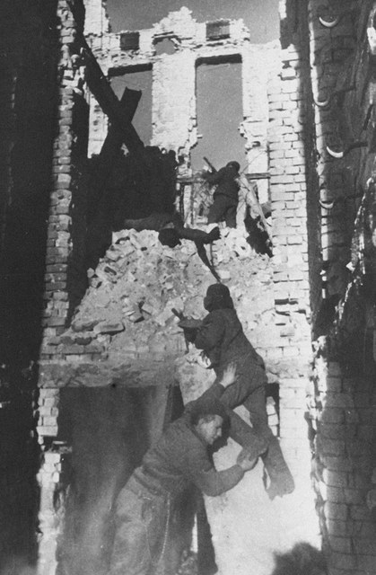 Archival photograph of Soviet infantry with submachine guns moving among brick ruins in Stalingrad, September 1942.